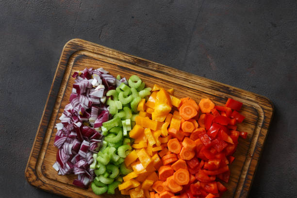 istock Chopped vegetables serving on cutting board on dark background close up, top view 935034956
