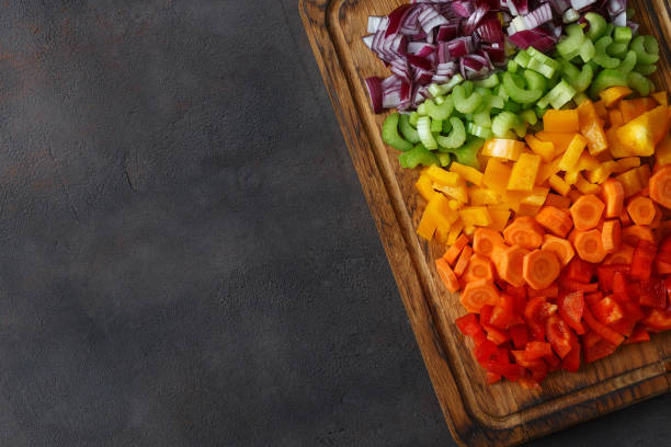 istock Chopped fresh vegetables arranged on cutting board on dark background with copy space, top view 935034962