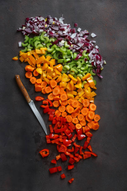 istock Chopped fresh vegetables with knife on dark background, top view 935035324