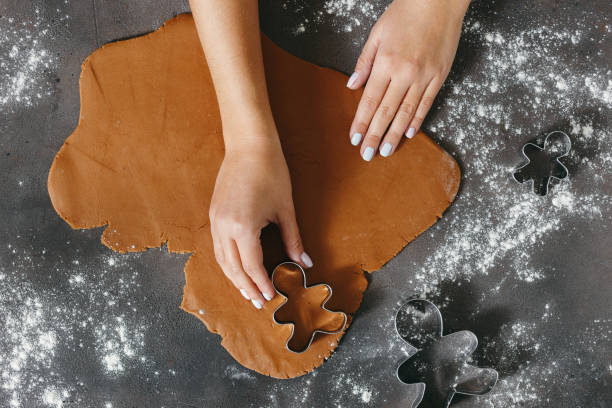 istock Female making festive Christmas gingerbread cookies top view 935035402