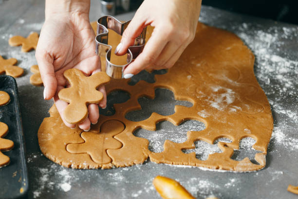 istock Female hands making festive Christmas gingerbread cookies. 935035584
