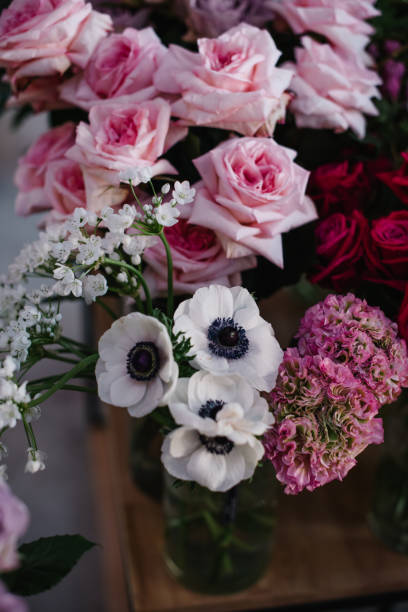 istock Beautiful and modern floral composition with anemones, roses, ranunculus and hydrangea with black and white matte paper at the city flower market 935049548