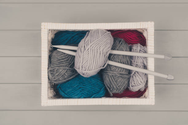 istock Knitting background with wool and needles on gray wooden table 935064878