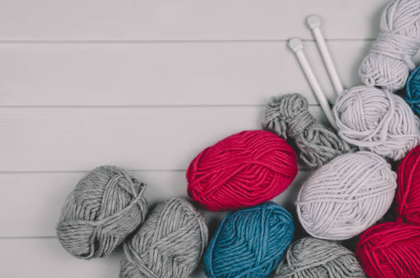 istock Knitting background with wool and needles on gray wooden table 935068614
