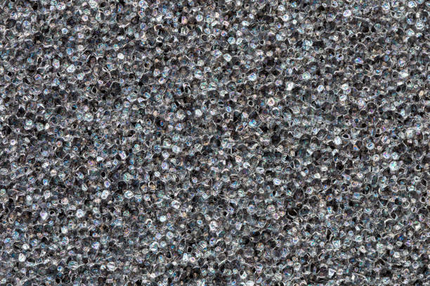 istock Close-up black  polyurethane foam texture. Rainbow film flares. Abstract black cellular background 935072424