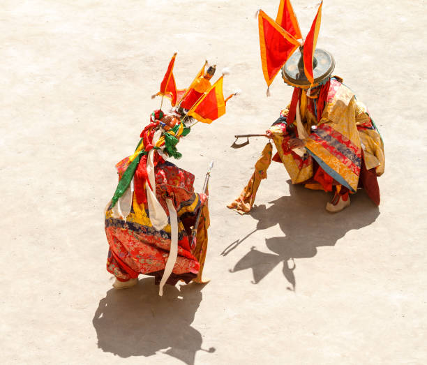 os monges não identificados realizar uma batalha simbólica durante a dança religiosa mascarados e fantasiados de mistério do budismo tibetano durante o festival de dança de cham no mosteiro lamayuru - cham mask - fotografias e filmes do acervo