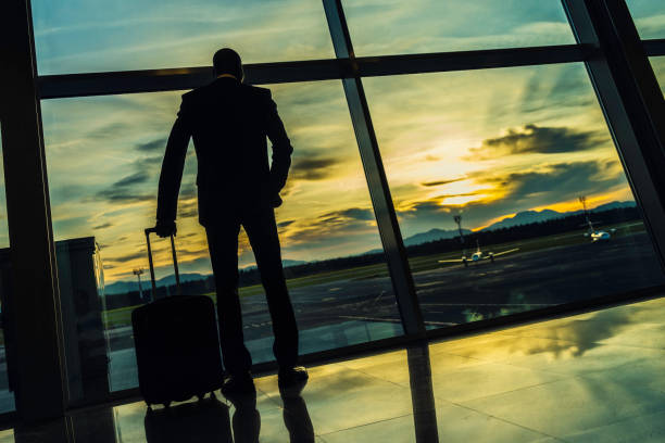 istock Businessman looking at sunset through airport window 935090256