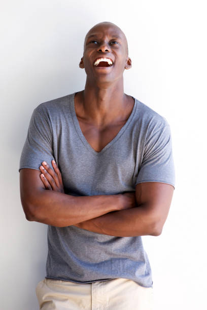 istock handsome african american man laughing with arms crossed 935110300