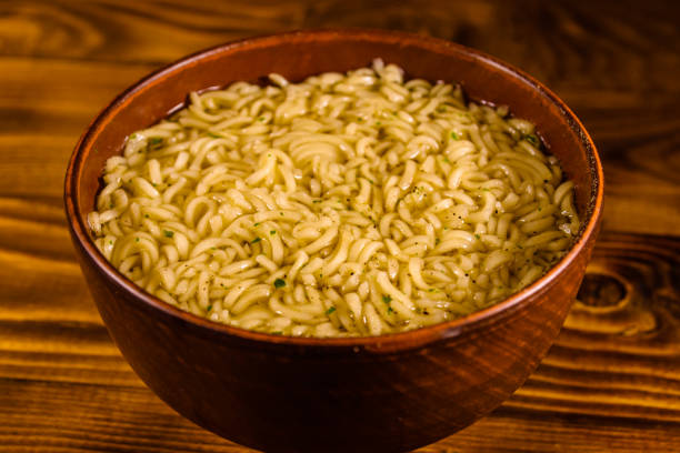 istock Ceramic bowl with prepared instant noodles on wooden table 935122868