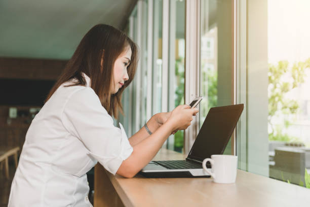 istock Beautiful woman using smartphone searching information and laptop 935138652