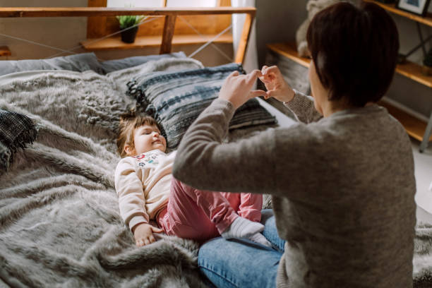 istock Mother and daughter playing in bed 935145080