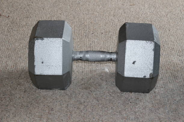 istock dumbbells over CARPET background. THIS IS A 90LB DUMBBELL 935148530