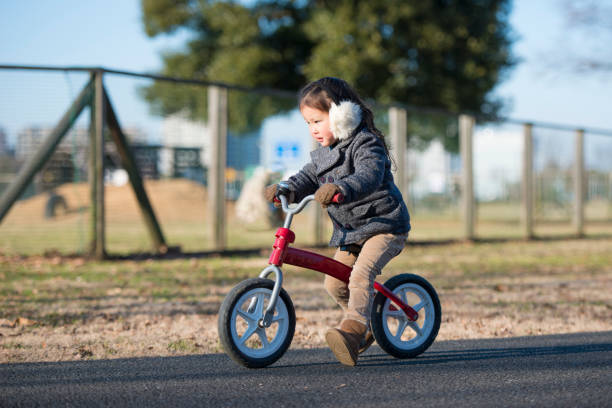 istock Little girl playing with bicycle 935150780