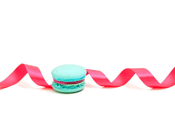 Valentine's blue macaron with pink ribbon on white background, minimal concept holiday