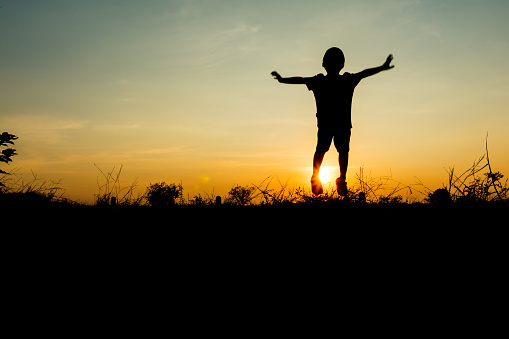 Silhouette a boy jumping at sky sunset