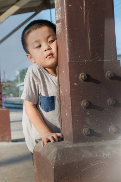 istock The child hides behind a pole 935161946