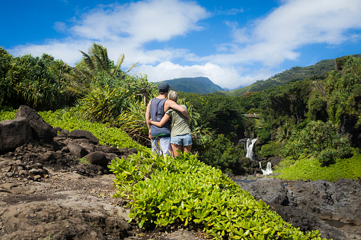 Couple hiking to scenic waterfall in Haleakala national park.