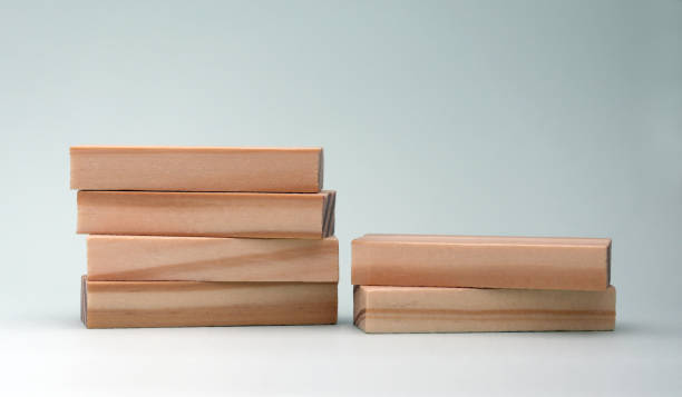 una pila di quattro blocchi di legno e una pila di due blocchi di legno. - tetragon foto e immagini stock