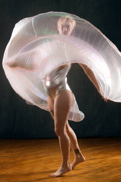 istock Young woman dancer turning with transparent, billowing cape. 935212376