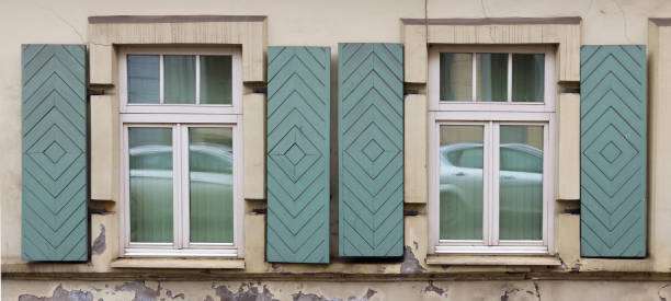 istock Two windows in the old house with open wooden shutters. 935227208