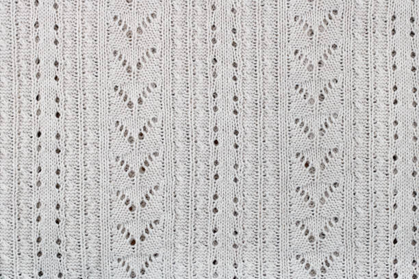 The female sweater is knitted from white cotton threads. A pattern in the form of triangles, holes and lines.Mass production
