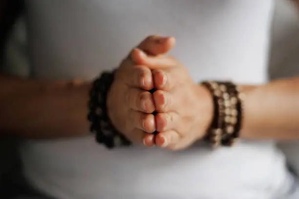 Photo of Woman hand yoga pose. Practicing meditation and praying indoors.