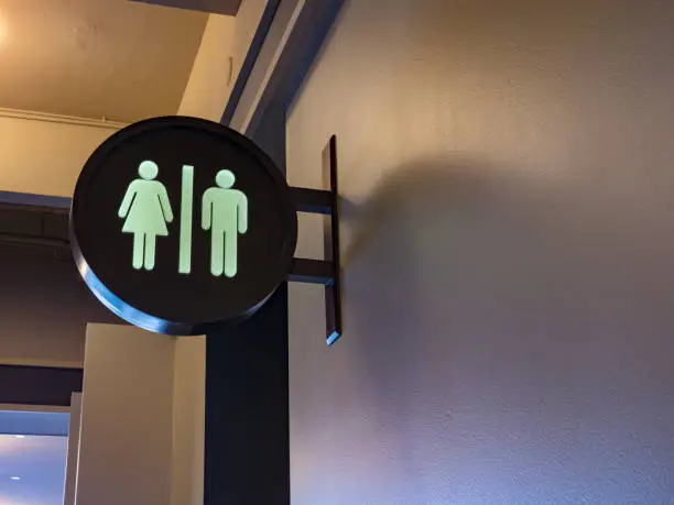 Men/Women restroom sign hanging in a public space