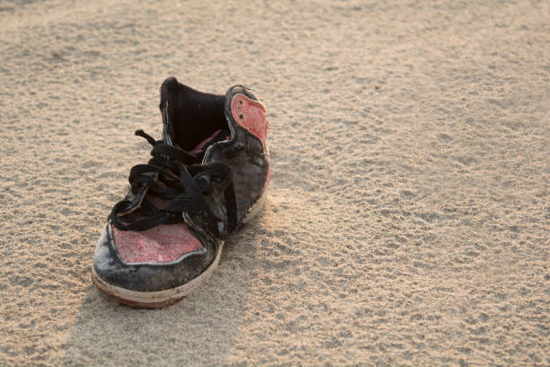 zapatos viejos en la playa. - lost beach fotografías e imágenes de stock