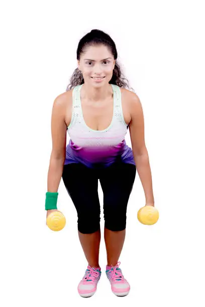 African woman holding two dumbbells while doing squat workout, isolated on white background