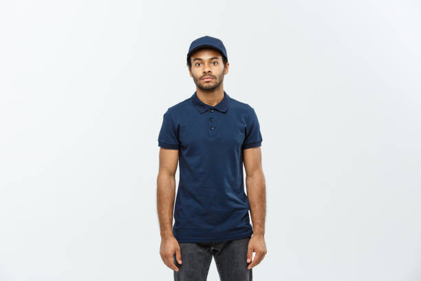 istock Delivery Concept - Handsome African American delivery man. Isolated on Grey studio Background. Copy Space. 935259634