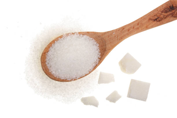 istock granulated sugar in wooden spoon with cube isolated on white background. Top view. Flat lay 935264968