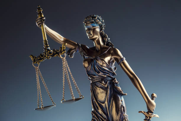 istock Statute of Justice. Bronze statue Lady Justice holding scales and sword 935265332