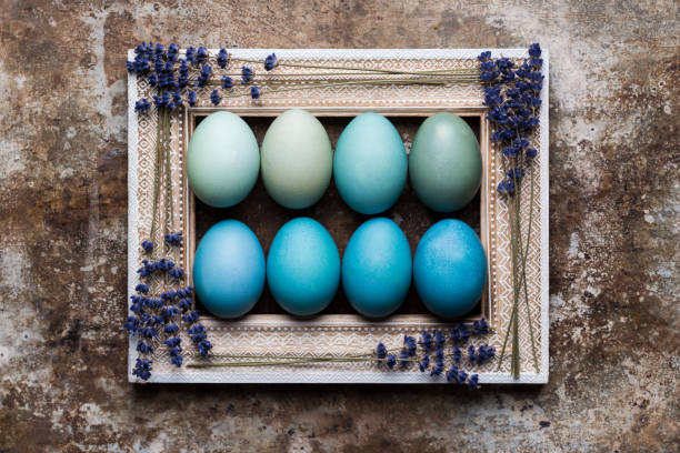 istock Happy Easter rustic background with copy space. DIY dyed various shades of blue Easter eggs and vintage wooden picture frame mock up. 935265370