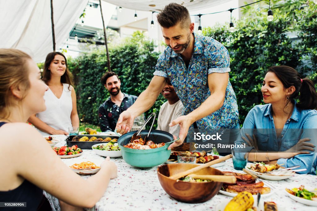 Grupo de diversos amigos curtindo a festa de verão juntos - Foto de stock de Prato de comida para levar em festa royalty-free