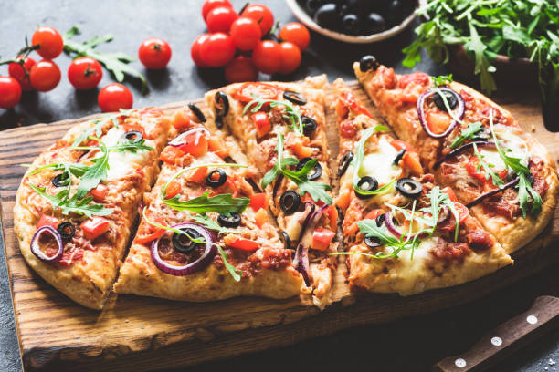 istock Homemade flatbread pizza sliced on wooden cutting board 935296930