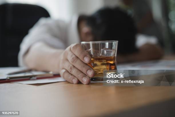 Photo libre de droit de Souligne Lhomme Daffaires Asiatique Tenant Un Verre De Whisky Il Dort Et Dimensionnelles Document Dentreprise Au Bureau Lalcoolisme Concept Ivre Homme Daffaires banque d'images et plus d'images libres de droit de Ivre