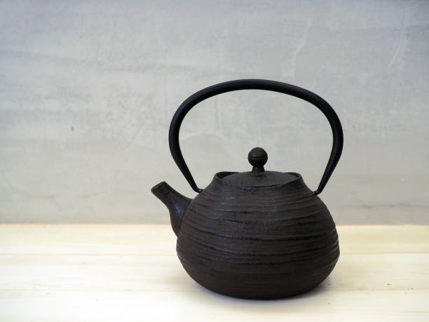 Metal black kettle isolated on wooden table.