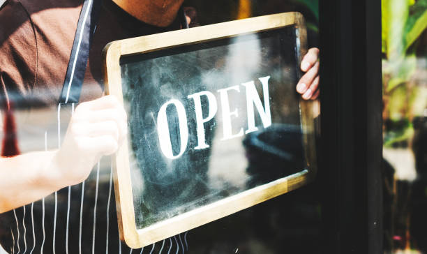istock Man putting on shop open sign 935301564