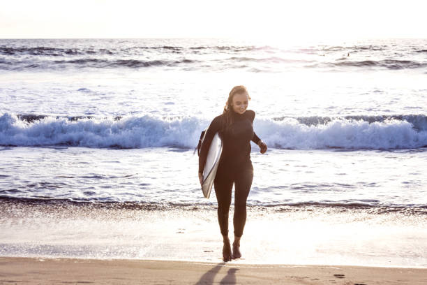 junge frau in kalifornien in großen wellen surfen gehen - santa monica surfing beach city of los angeles stock-fotos und bilder