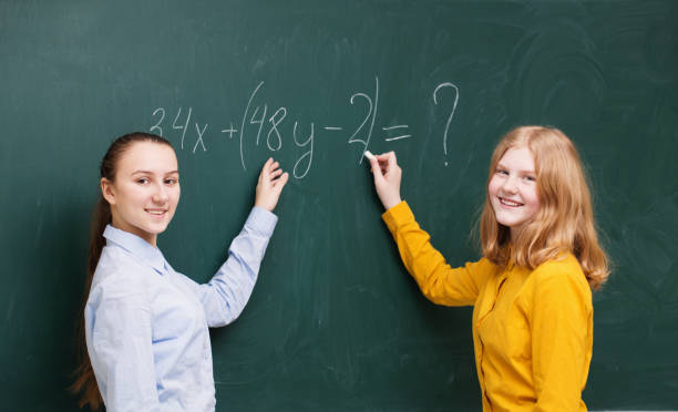 istock Two girls at the blackboard in a mathematics class 935304792