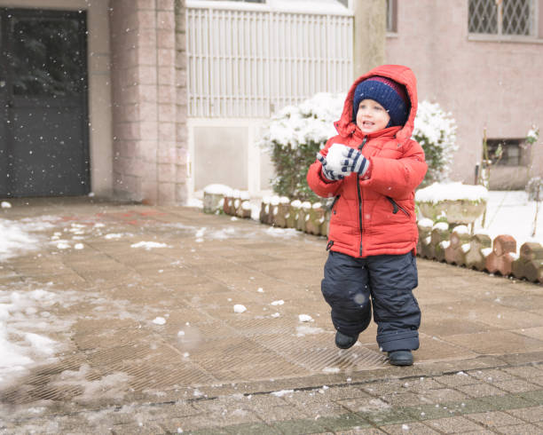 istock Infant runs with a snowball in his hands 935305476