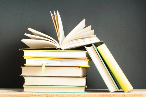 istock Open book, hardback books on wooden table. Education background. Back to school. 935308460