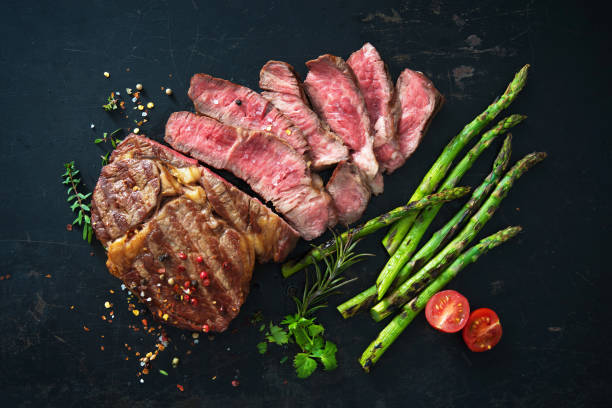 bistecca agli occhi di costolette arrosto con asparagi verdi - roast beef meat roasted beef foto e immagini stock