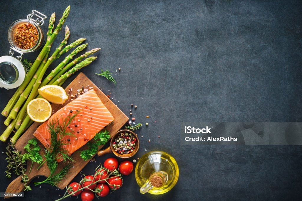 Fresh salmon fillet with aromatic herbs, spices and vegetables Fresh salmon fillet with aromatic herbs, spices and vegetables. Balanced diet or cooking concept Food Stock Photo