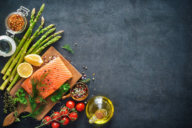 Fresh salmon fillet with aromatic herbs, spices and vegetables Fresh salmon fillet with aromatic herbs, spices and vegetables. Balanced diet or cooking concept olive oil photos stock pictures, royalty-free photos & images