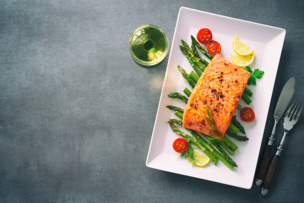 istock Grilled salmon garnished with green asparagus and tomatoes 935316746
