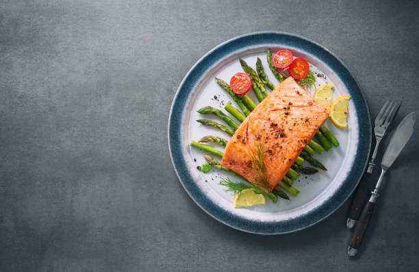 istock Grilled salmon garnished with green asparagus and tomatoes 935316754