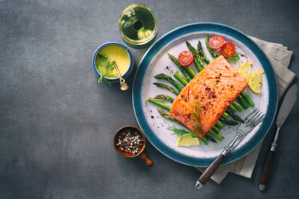 istock Grilled salmon garnished with green asparagus and tomatoes 935316758