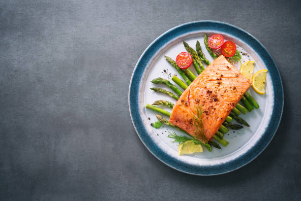 istock Grilled salmon garnished with green asparagus and tomatoes 935316770
