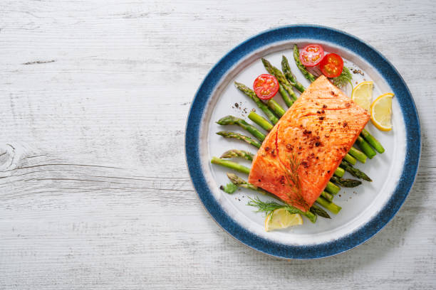 istock Grilled salmon garnished with green asparagus and tomatoes 935316780